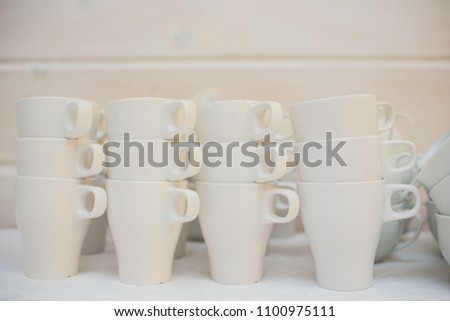 many rows pure white cup and saucer with teaspoon, reflection on table