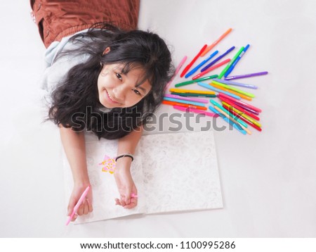 happy smiling girl colouring on peper with variety color pen fall all shade