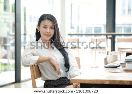 Portrait of attractive young asian woman sitting at home office in front of her laptop