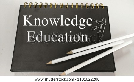 Knowledge education memo written on a notebook with pencil and paper clip