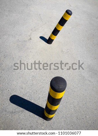 Street of the summer city. On the road fence. Striped yellow pillar. Photographed in Ukraine, Kiev. Horizontal frame. Color image