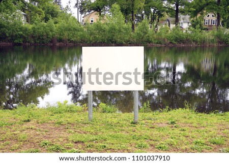 Blank sign next to a lake in a park. Template.