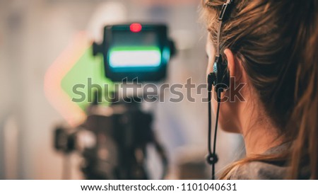 Behind the scene. Female cameraman shooting the film scene with camera in film studio