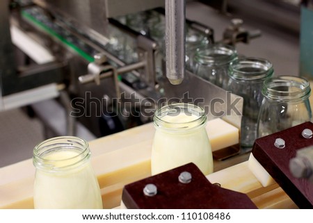 Conveyor with bottles filled with milk products Royalty-Free Stock Photo #110108486
