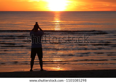 Man take a sunset photo  with smartphone