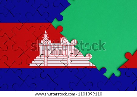 Cambodia flag  is depicted on a completed jigsaw puzzle with free green copy space on the right side