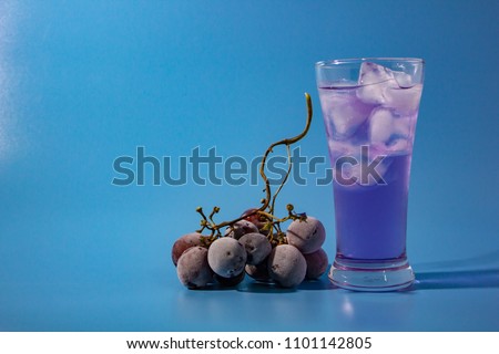 cocktail with grape on blue background right position.