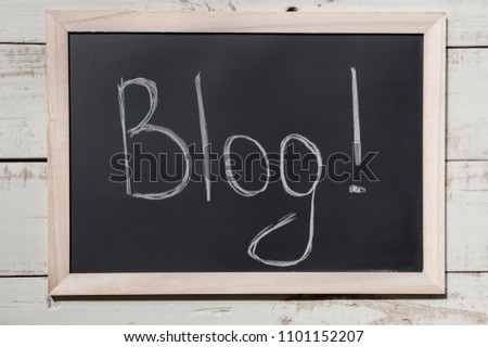 Blackboard with text "Blog!" on wooden background. Blogging in internet marketing strategy. Digital marketing concept