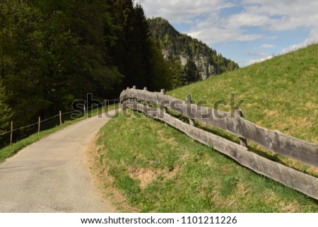 wooden fence on grassy hills along a road