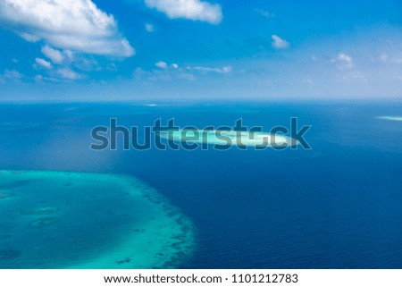 Beautiful view from the plane on the island located in the Maldives. Coral reef and blue sea panorama, aerial photo