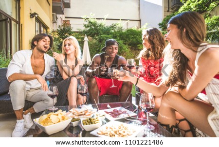 Multiethnic group of friends making party in a lounge bar - Cheerful young adults having fun and celebrating in a backyard garden with swimming pool