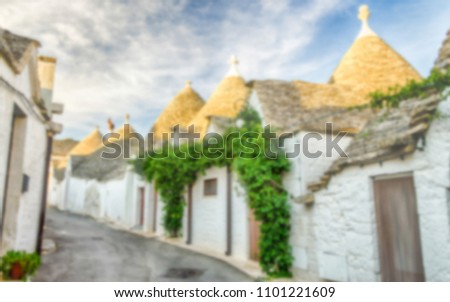 Defocused background with typical trulli buildings in Alberobello, Apulia, Italy. Intentionally blurred post production for bokeh effect