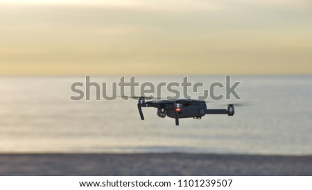 Drone flying over san  beach with sunrise . The drone with the professional camera takes pictures.