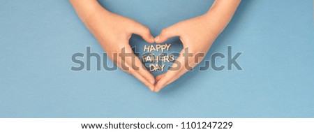 Happy Father's day banner with childs hands in shape of heart and wooden letters inside. Concept card.