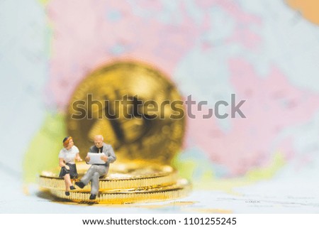 Miniature people: Businessman on stack of coin with world map background , Money and financial business success concept.