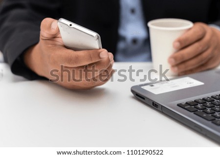 business man on cup paper coffee in hand with mobile phone copy space