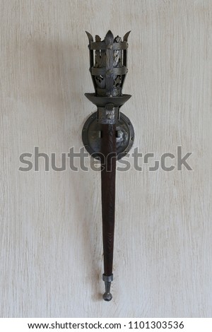 The lamp in the apartment, made as a mid-torch torch in the castle. Royalty-Free Stock Photo #1101303536