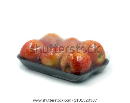 black peel with six apples wrapped in transparent plastic isolated on white background Royalty-Free Stock Photo #1101320387