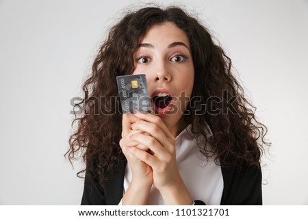 Photo of excited shocked young business woman with credit card isolated over white wall backgound looking camera.