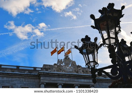 old buildings facade with cloudy blue sky and city lamps in Barcelona, Spain
