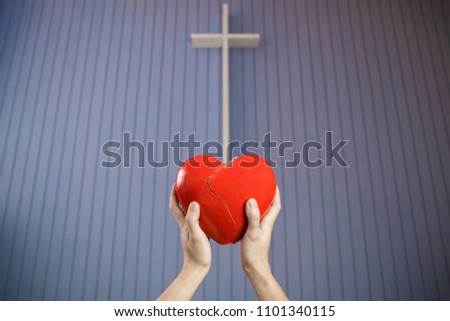 Surrendering broken heart to the cross, conceptual Christian photo