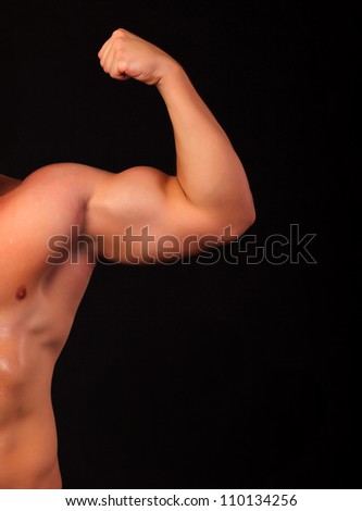 Strong arm of a male athlete, isolated on black background