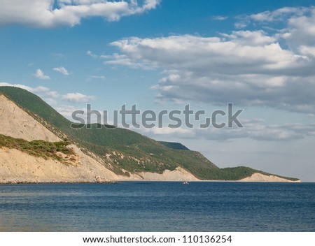 summer landscape with sea, rocks and blue sky with clouds