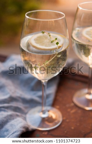 Glass with sparkling refreshing lemonade, lemon water or sparkling wine