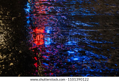 Neon reflection on the sidewalk after the rain