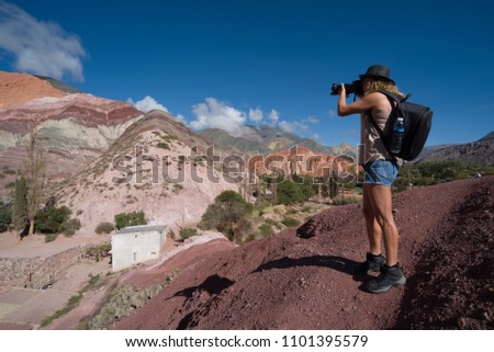 Beautiful woman photographer with dslr camera hat and backpack