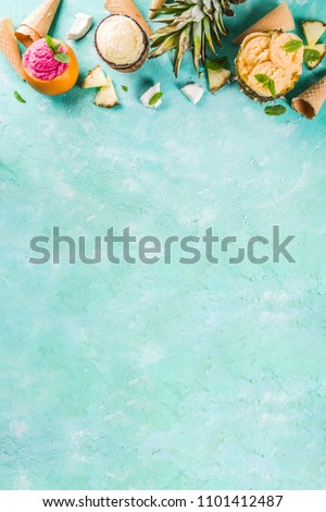 Summer holiday vacation concept, set various tropical ice cream sorbets, frozen juices in pineapple, grapefruit and coconut, light blue concrete background copy space