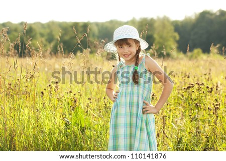 Beautiful girl among the tall grass in the summer