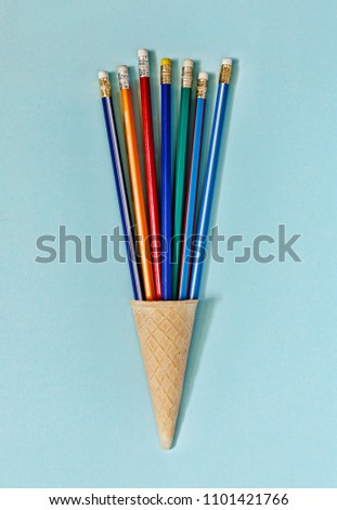 minimalism. Ice cream cone with colorful pencils on blue background. business concept. top view. copy space