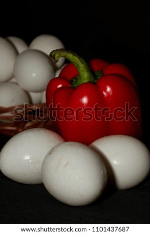 White chicken eggs and red sweet pepper. Vertical photo close up