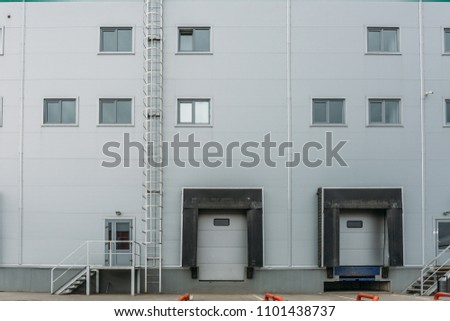 Distribution warehouse and logistics building exterior with gates, copy space
