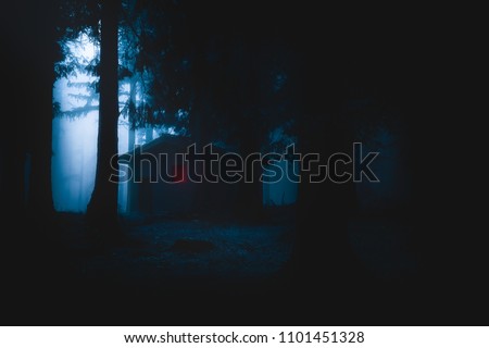 scary house illuminated in mysterious horror forest at the night