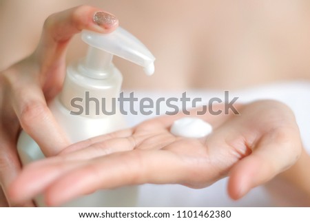 Closeup of female hands pumping out cream, lotion from white bottle, selective focus, Hygiene skin body care concept, selective focus.
 Royalty-Free Stock Photo #1101462380