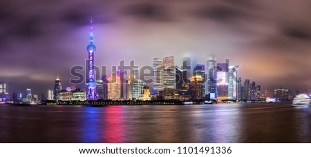 Panoramic view to the illuminated skyline of Shanghai on a foggy night, China