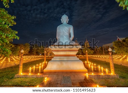 The light from the candle lit at night around the Church of Buddhist Visakha Bucha Day at Temple (Wat Ban Taew) in Beautiful Sky Evening  in Phitsanulok, Thailand