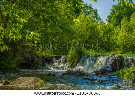 small nature waterfall in summer green forest landscape