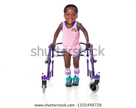 Young girl with cerebral palsy taking steps with her walker Royalty-Free Stock Photo #1101498728