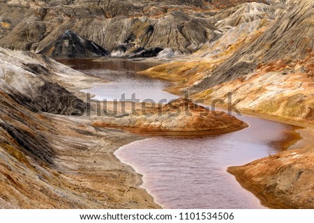 lake with red water with dissolved pyrite salts in the desert landscape of a spent quarry


