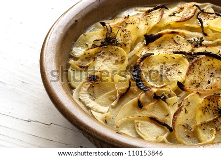 Potato gratin boulanger, in rustic dish.  Delicious sliced potatoes with onions, garlic, herbs and a vegetable stock.