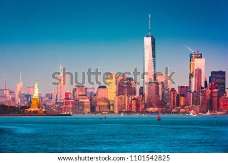 New York, New York skyline of Manhattan from the harbor at dusk.