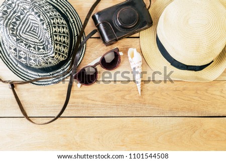 two straw hats, sunglasses and camera on a wooden background, banner