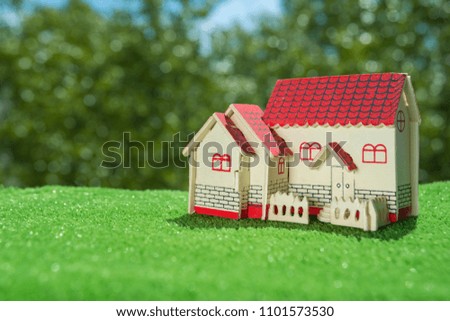 wooden house on the background of grass and greens. The concept of eco-friendly housing, purchase of sale, lease, credit, mortgage.
