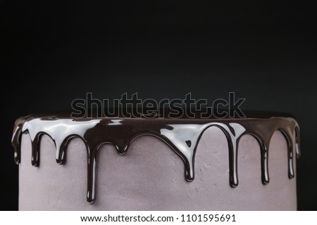 Chocolate cake with black glaze on a black background. Picture for a menu or a confectionery catalog.