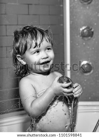 Child Childhood Children Happiness Concept. Cute happy smiling funny undressed boy child with blonde curly wet hair taking shower in bath with water indoor, vertical picture