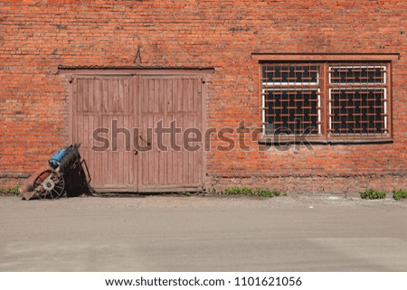 Repair shop: a brick building with a wooden gate and a set for gas welding