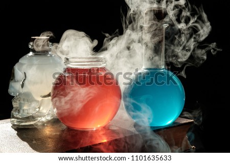 Magic and wizardry concept. Set of sorcery book, magic potions and candles on table. Health and mana potion. Alchemy concept. Royalty-Free Stock Photo #1101635633